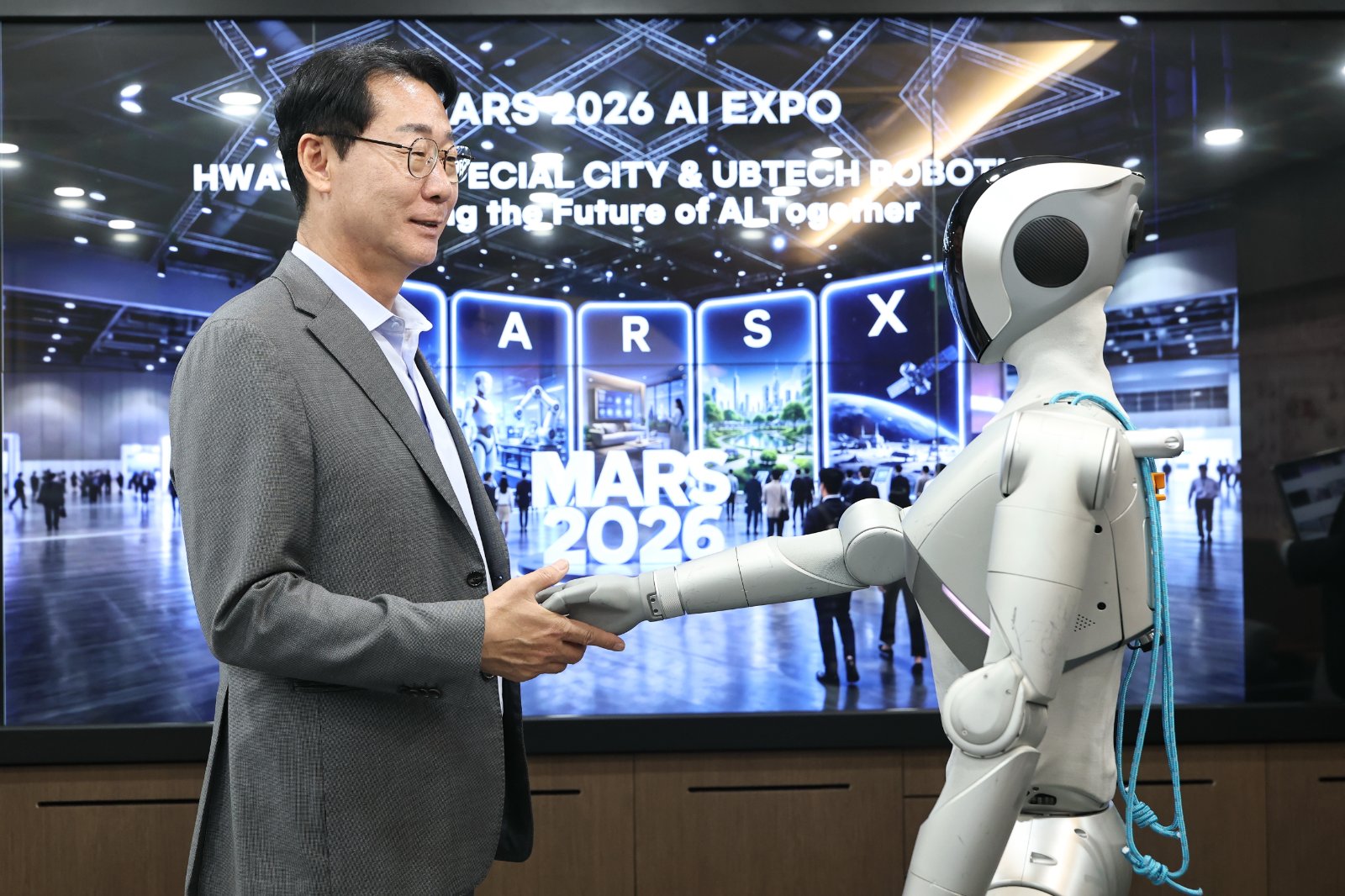 정명근 화성특례시장이 「MARS 2026」 개막식 오프닝 무대에서 발레 퍼포먼스를 선보일 로봇 ‘루나(LUNA)’와 악수를 하고 있다